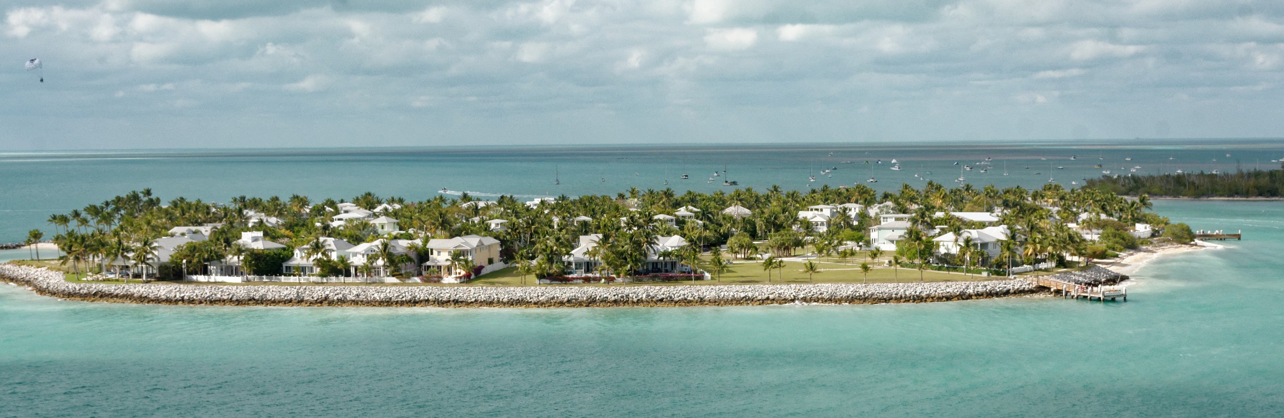 Coastal homes and turquoise water; illustrative property imagery